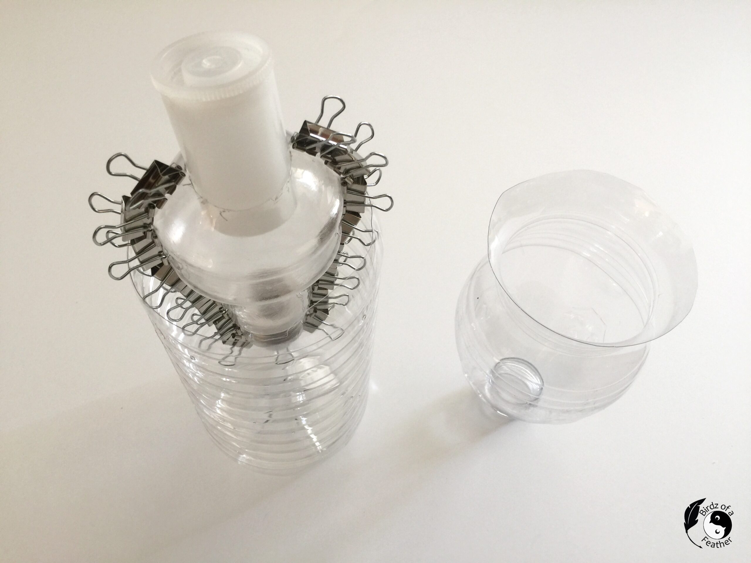 Setup for cement planter molds. Binder clips hold side of plastic packaging together so cement can be poured into it. 