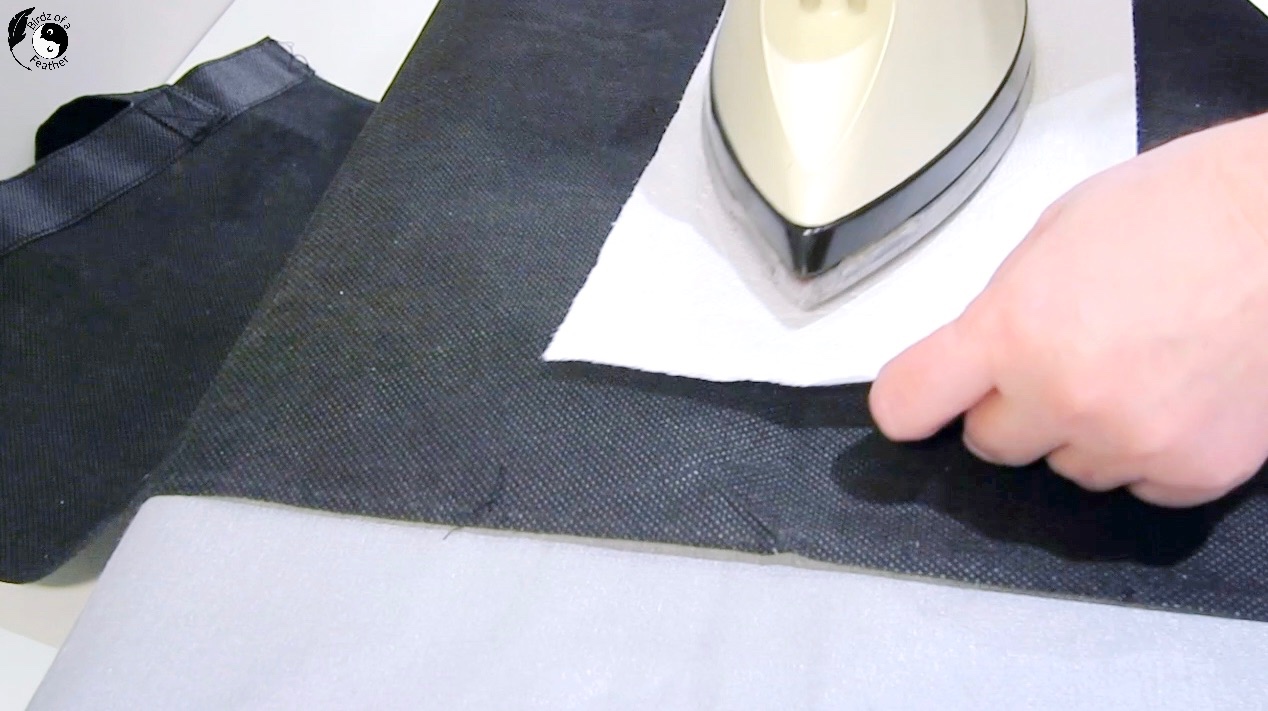 Using a cloth to iron reusable shopping bag for sling water bottle bag
