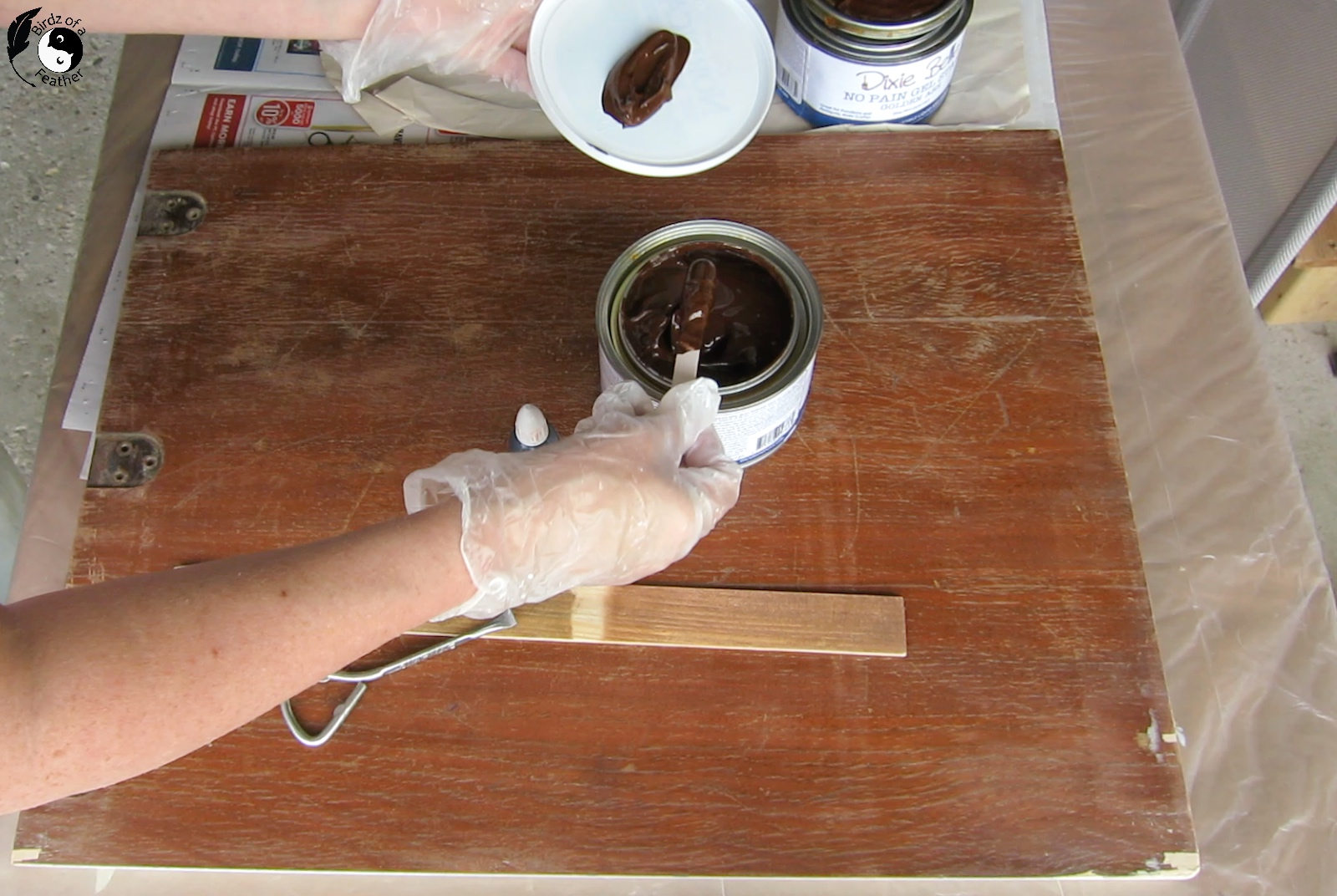 Scooping stain out of tin onto a plastic lid before showing How to Change Stain Color