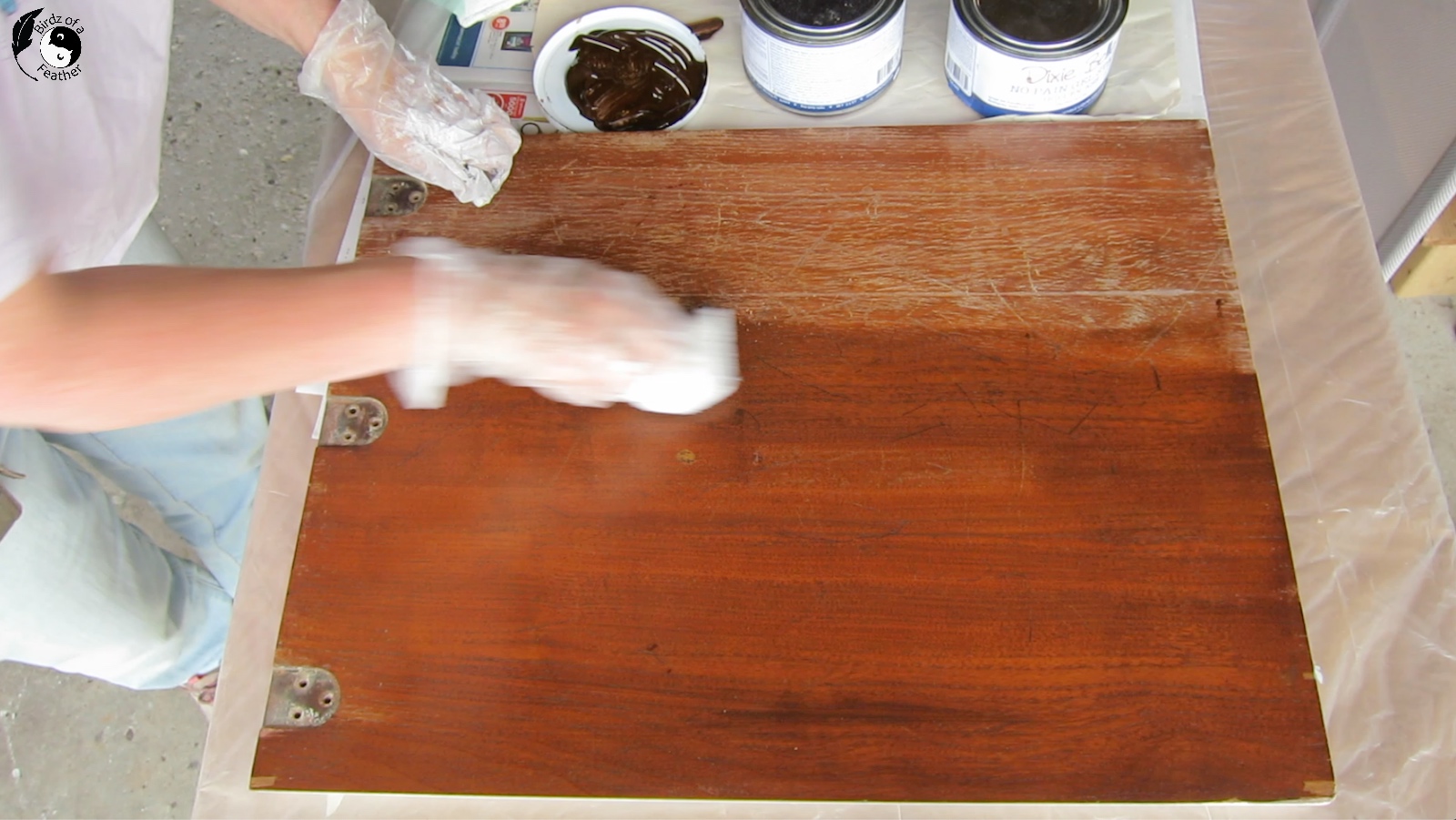 Applying the stain with applicator pad to 3/4 of the sewing table lid
