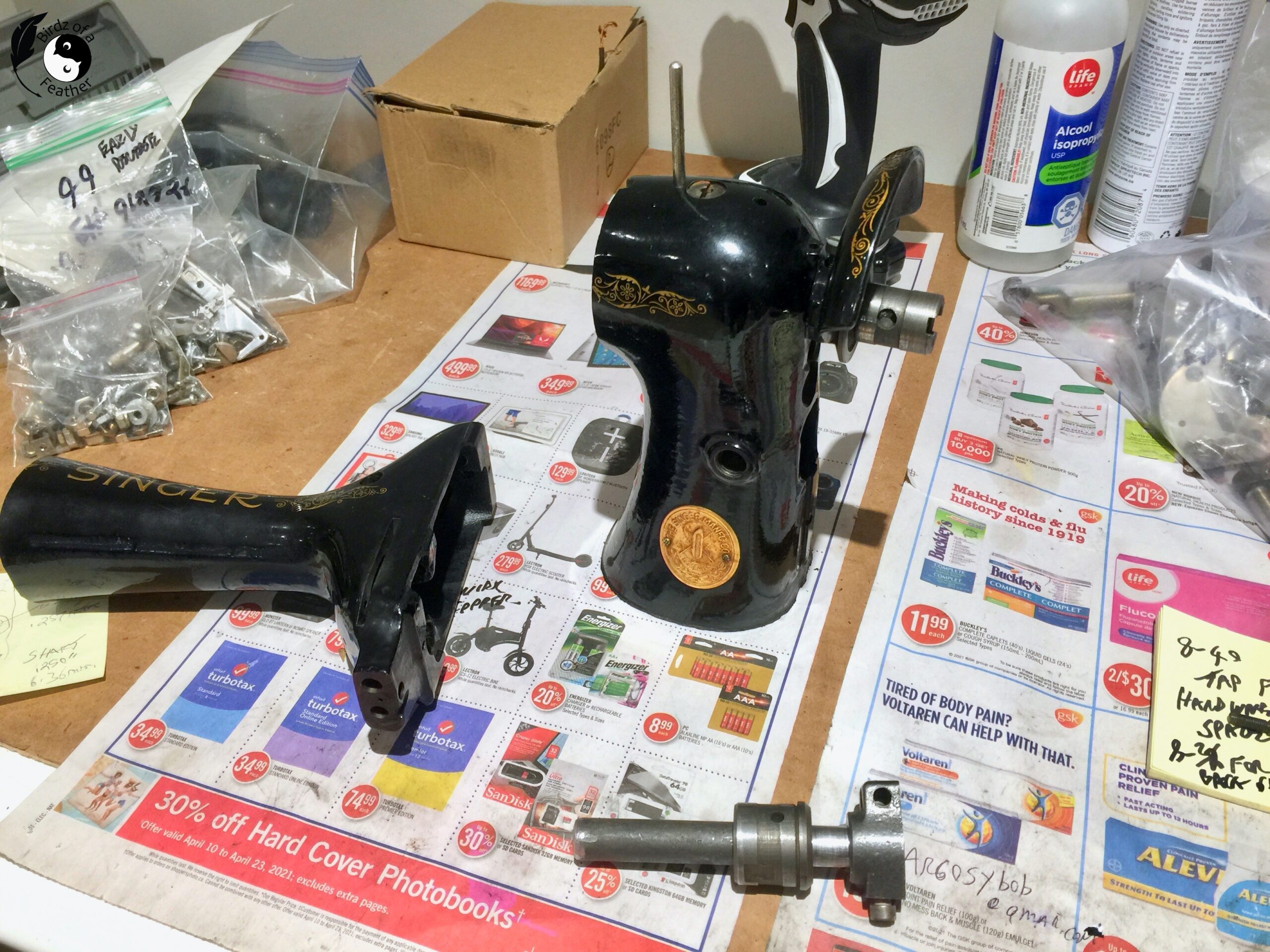 Two halves of sewing machine for DIY bookends on table covered in newspaper with cut shaft in foreground