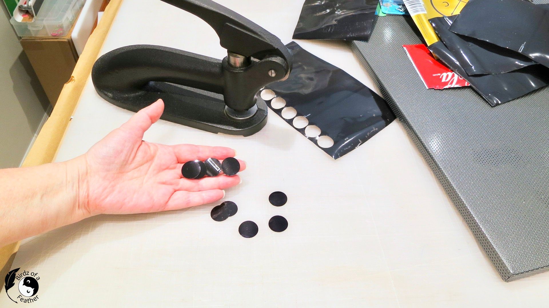 Hand holding punched circles for soda can craft