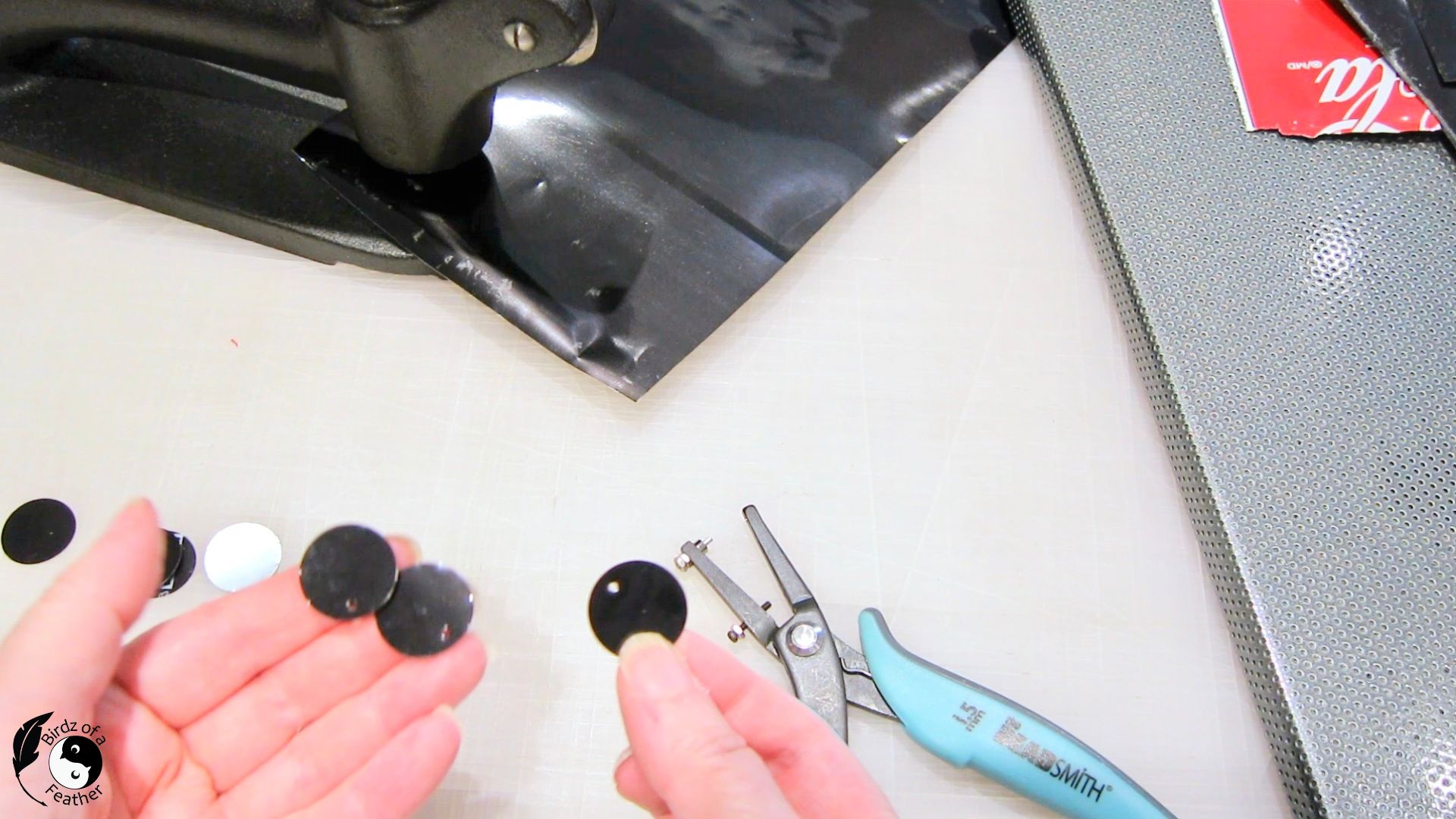 Hand holding circle punches with nail holes