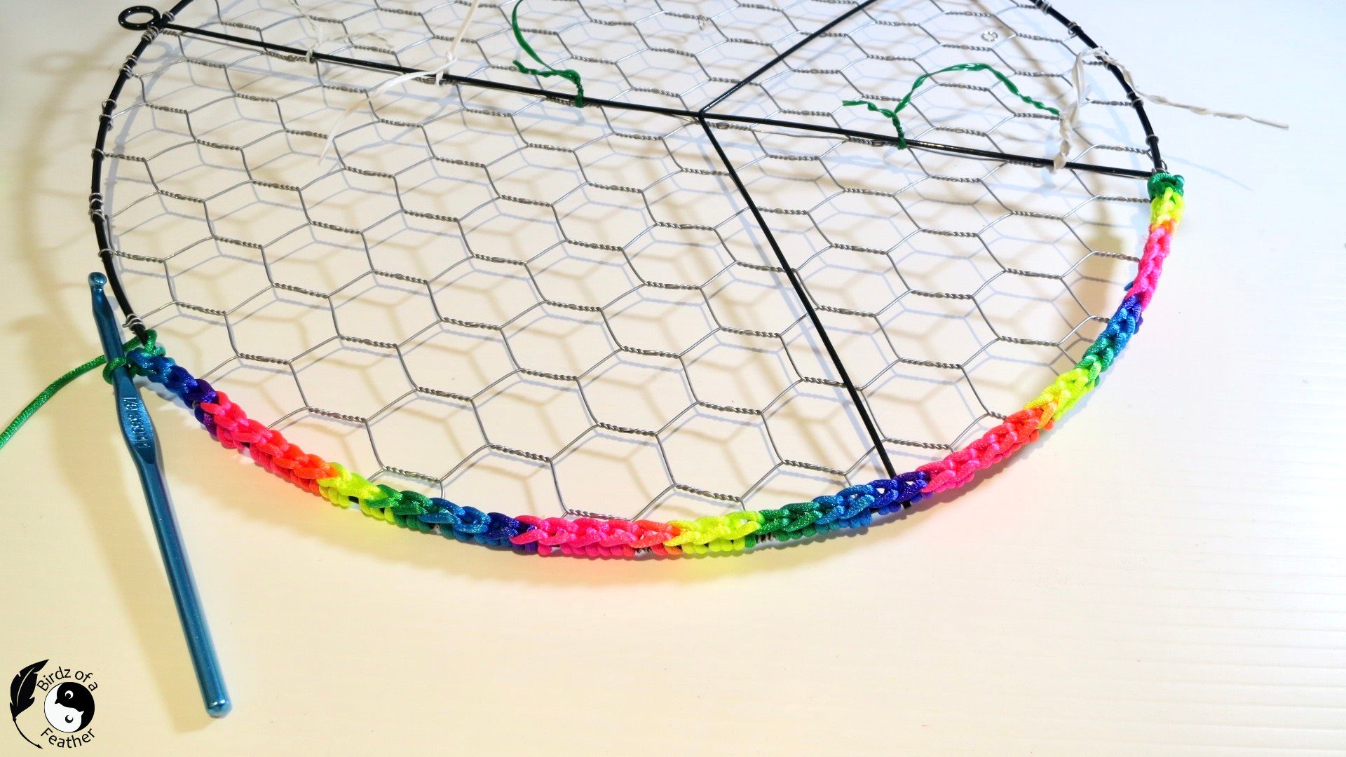 Edge of suncatcher DIY showing crochet hook and ombre rattail cord around edge