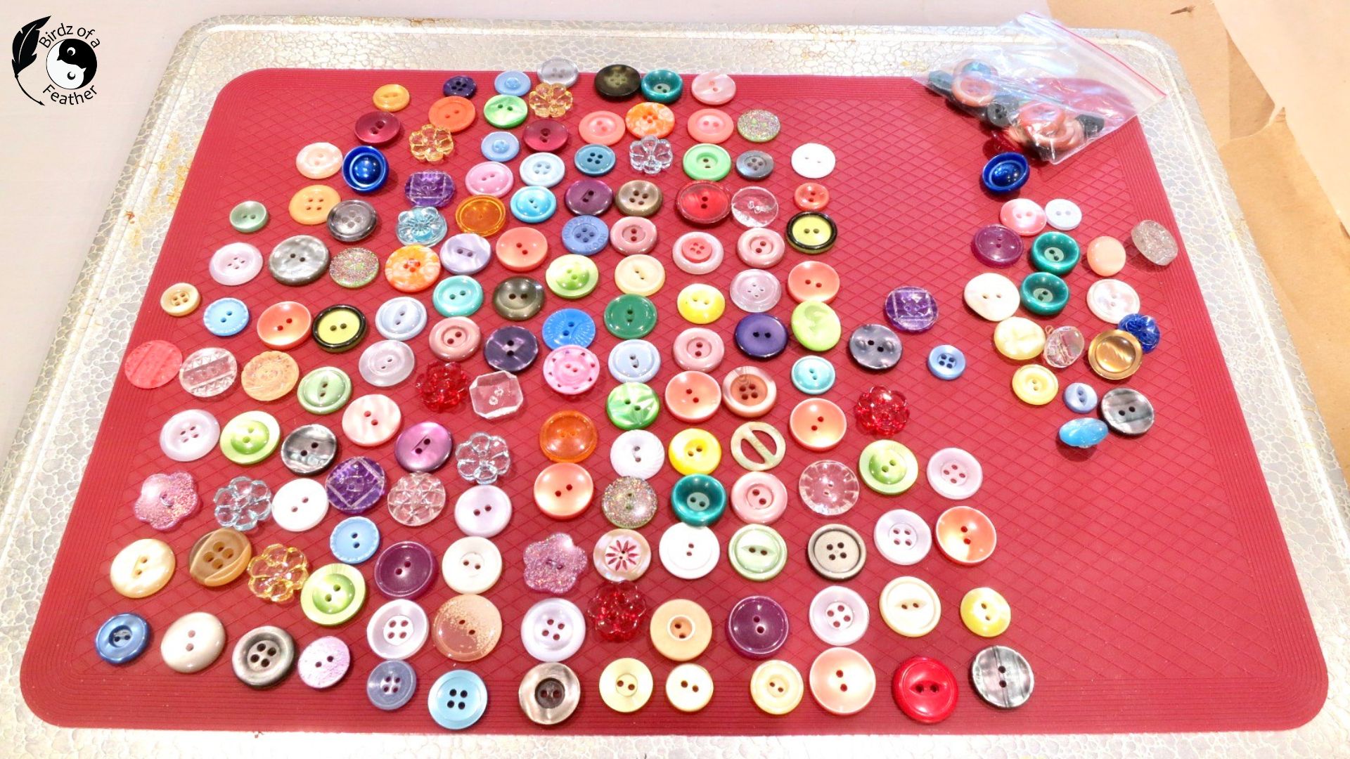 Buttons laid out on a silicone mat for suncatcher DIY