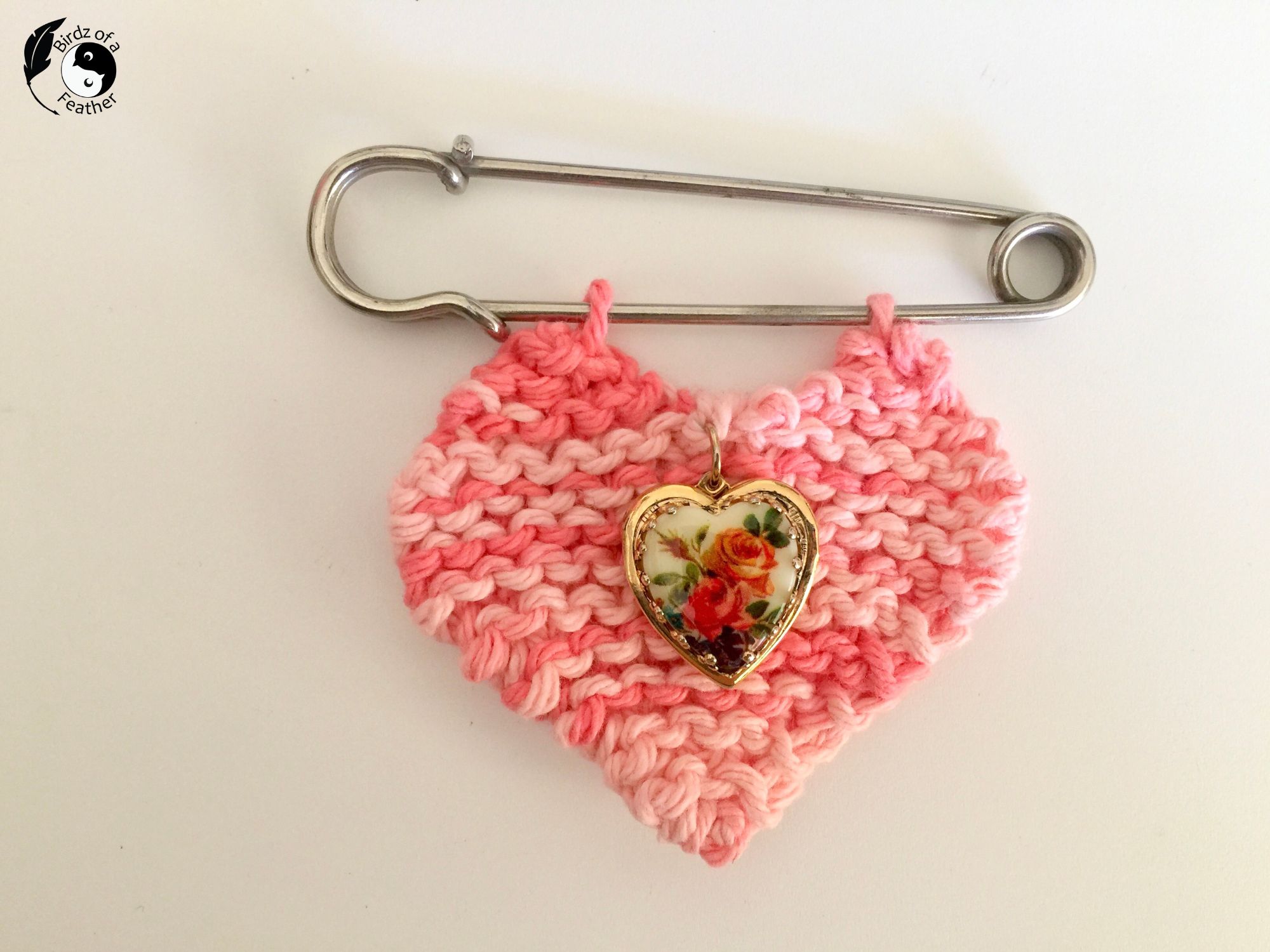 Knit heart and rose locket hanging from a kilt pin for version 1 of DIY Charm Necklace