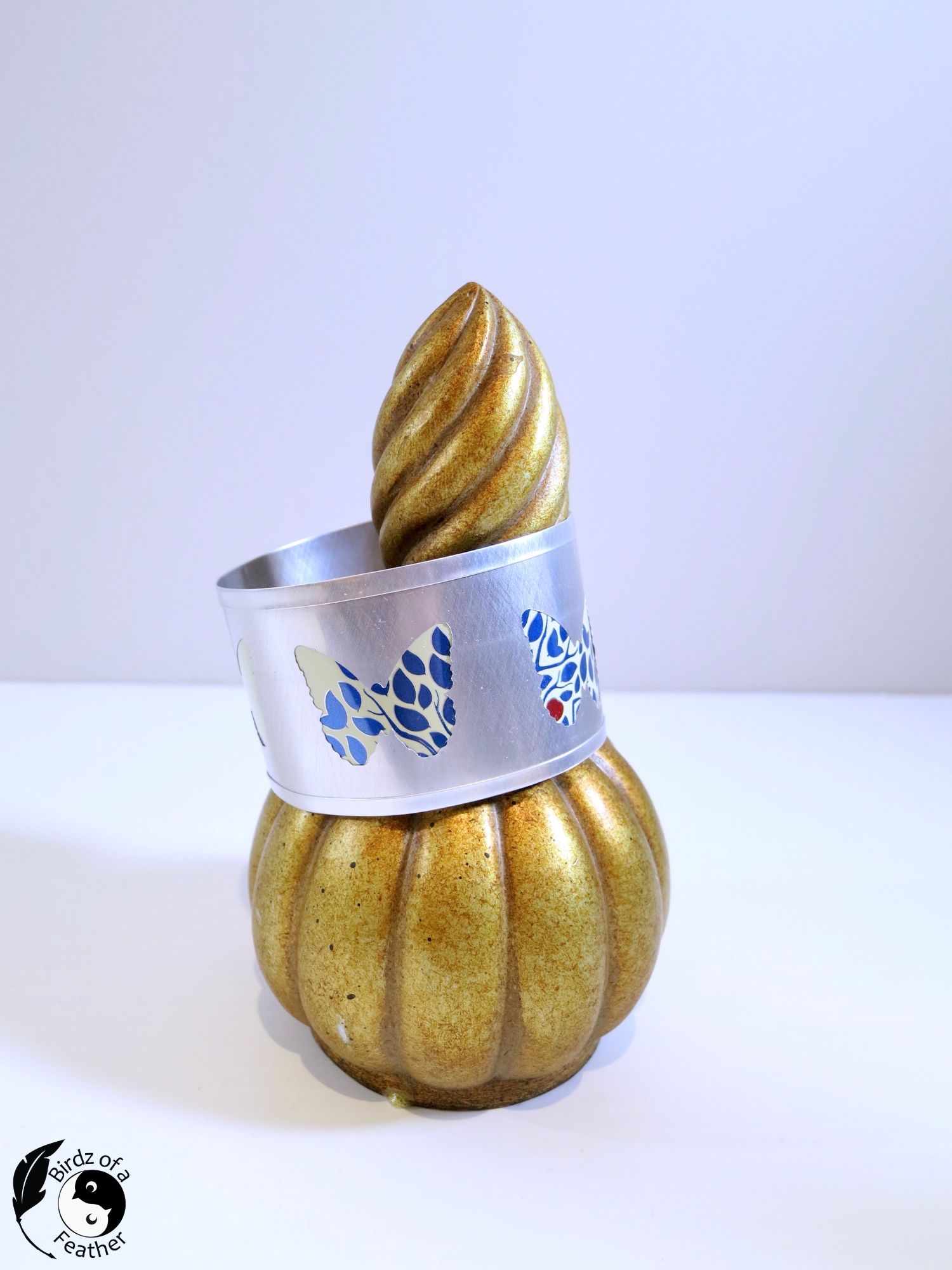 Completed DIY soda can bracelet displayed on a finial