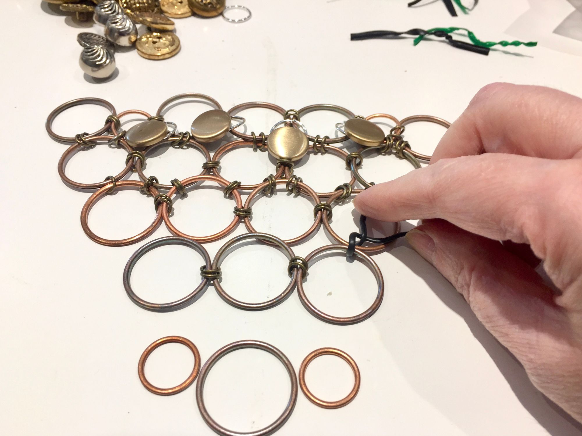 Adding twist ties to vintage button necklace framework