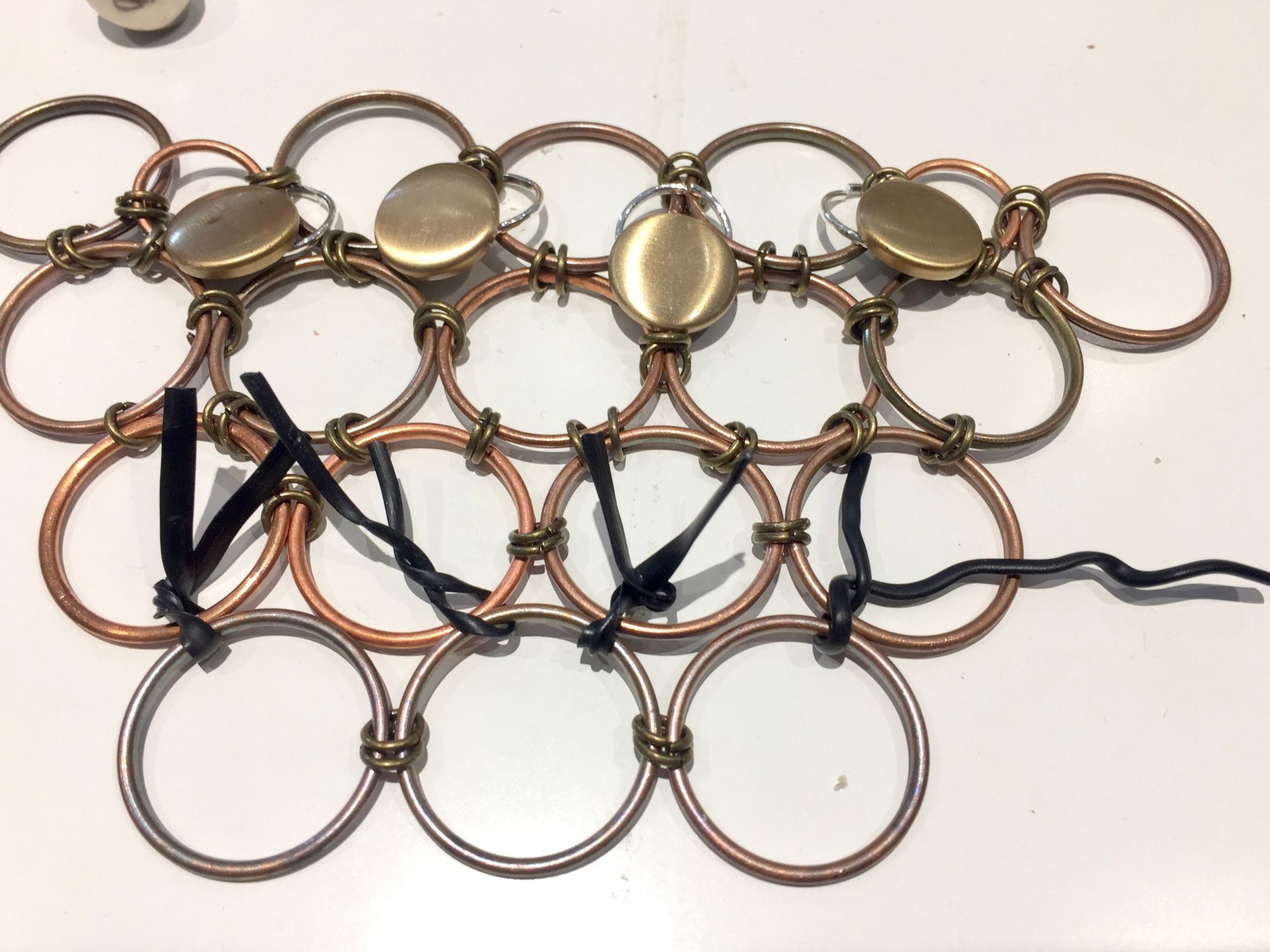 Twist ties around third row of washers of vintage button necklace framework